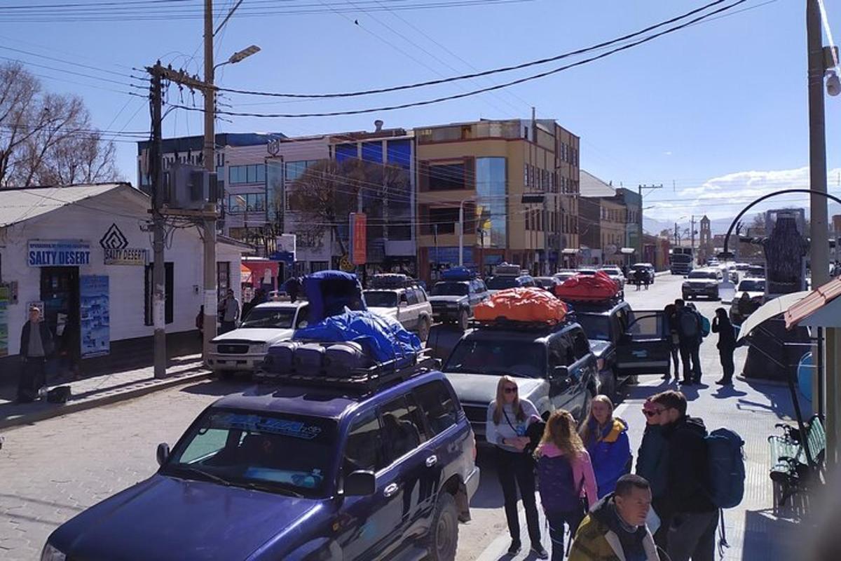 a group of people walking down a street with cars