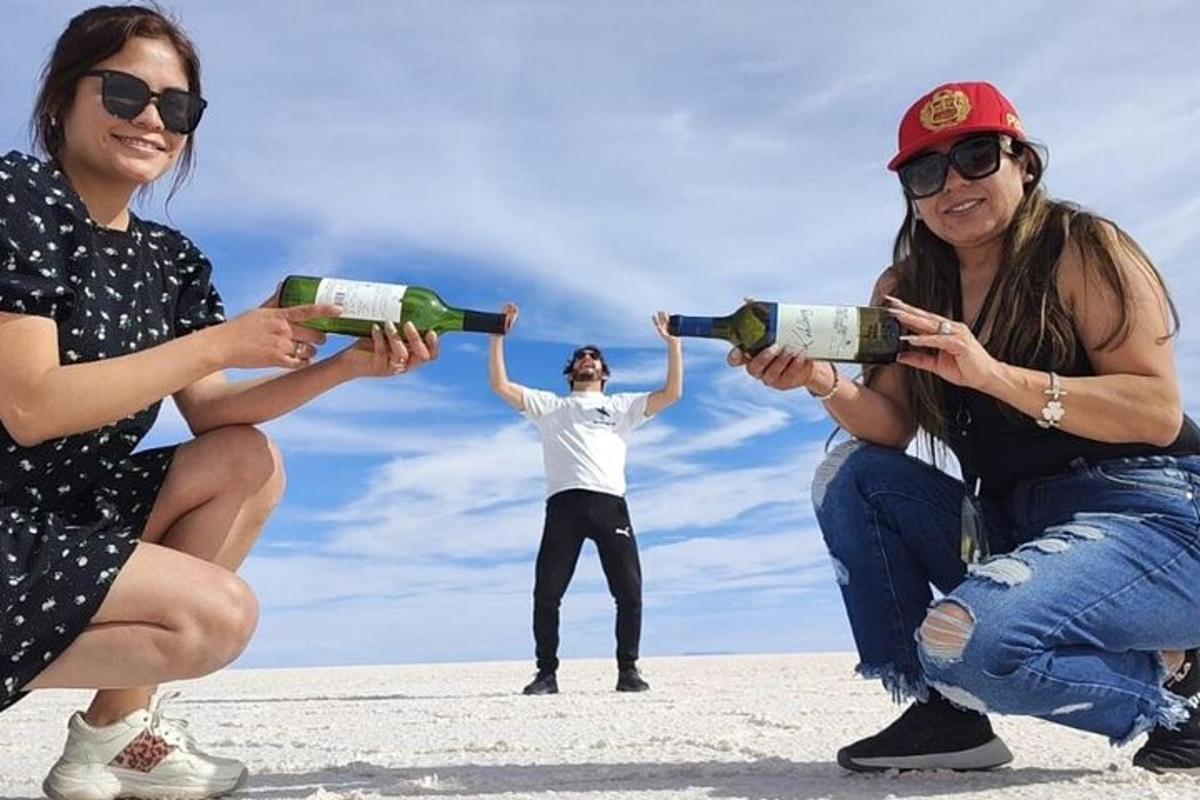 a group of three women holding up bottles of wine