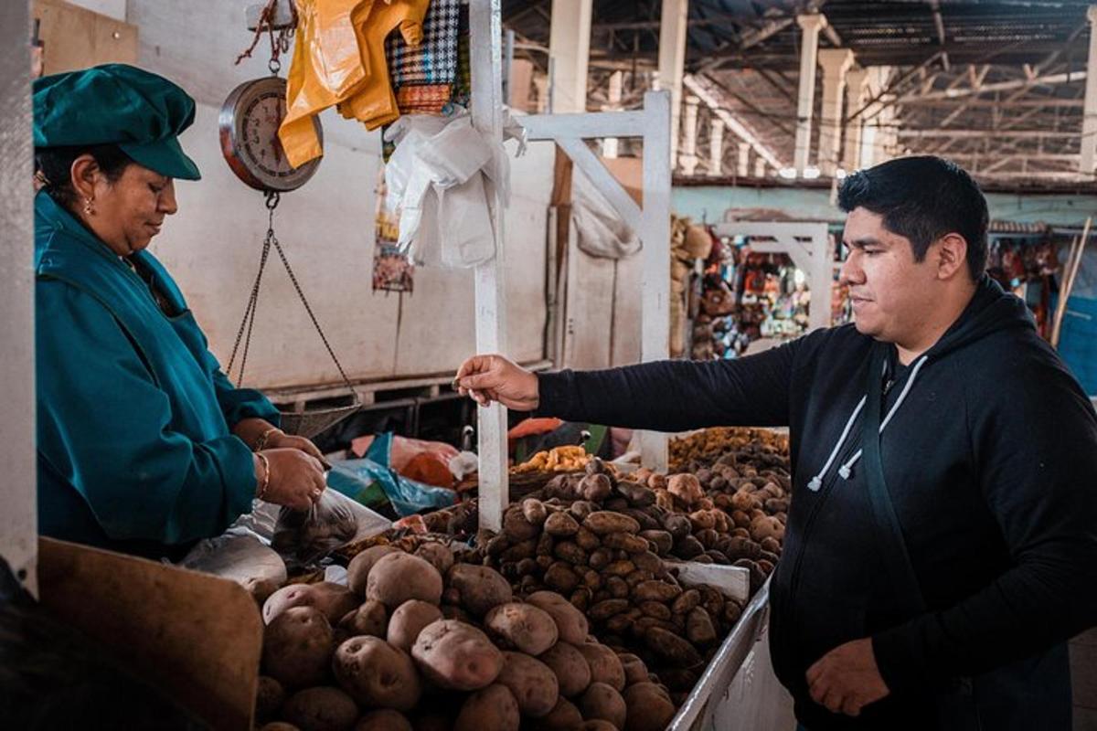 un home està dret en un mercat venent patates