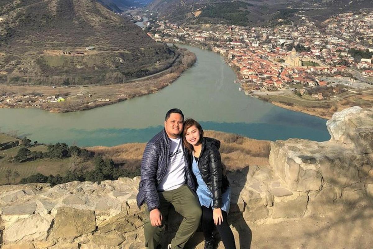 un uomo e una donna seduti in cima a una montagna
