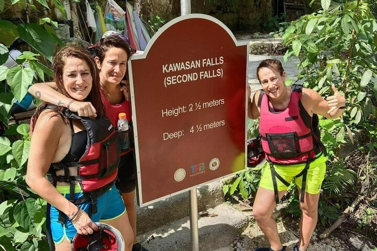 un gruppo di tre donne in piedi accanto a un cartello