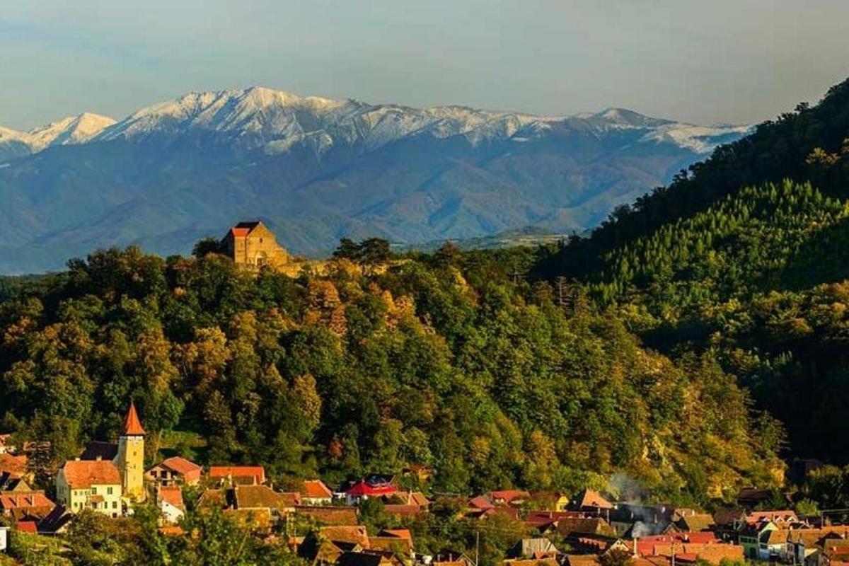 uma cidade no topo de uma colina com montanhas
