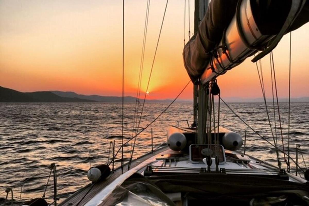 a boat in the ocean with a sunset in the background