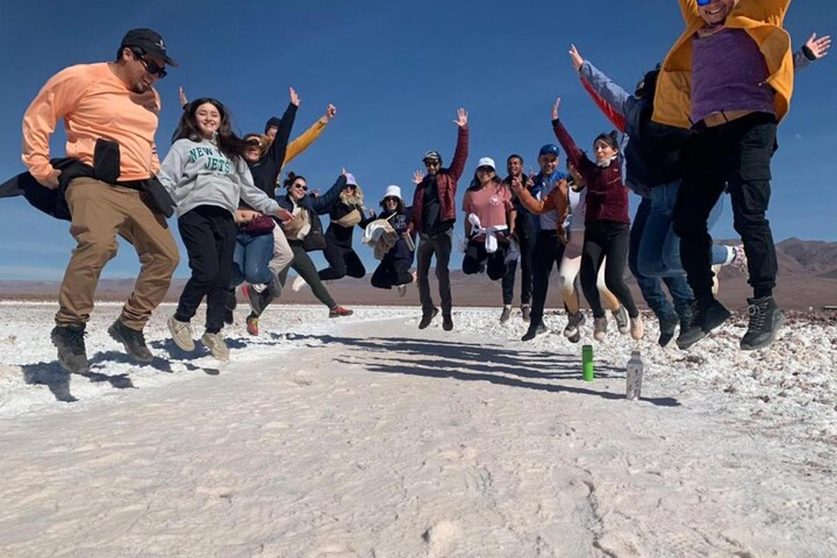 a group of people jumping in the sand
