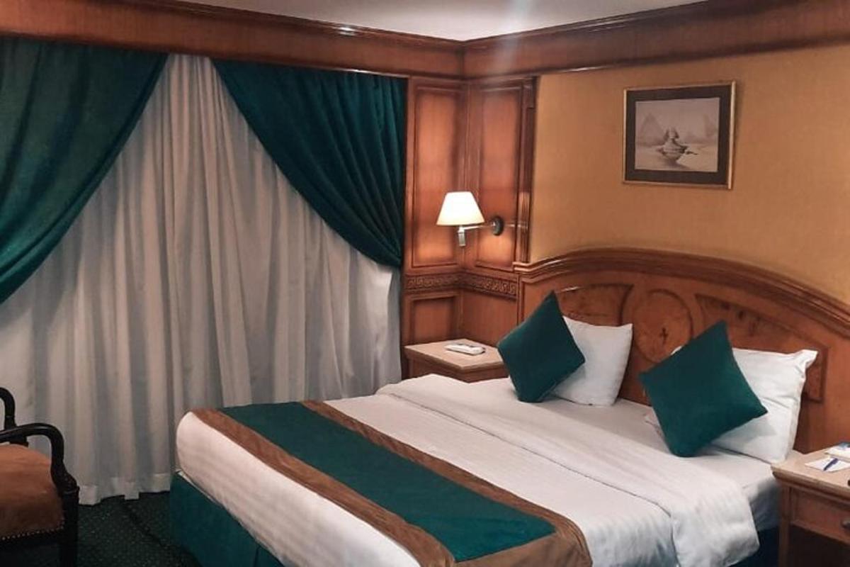 a hotel room with a large bed with green pillows