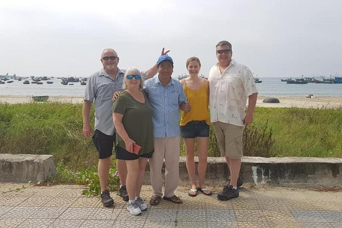 a group of people posing for a picture at the beach
