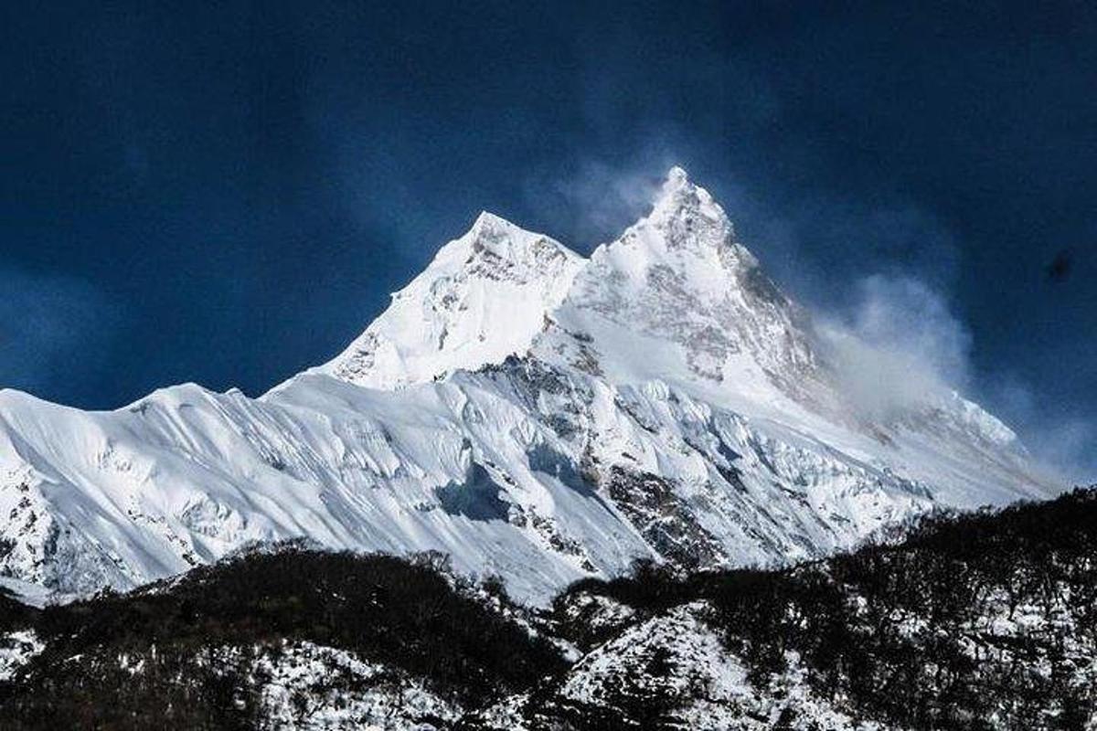gunung yang dilitupi salji di hadapan langit biru