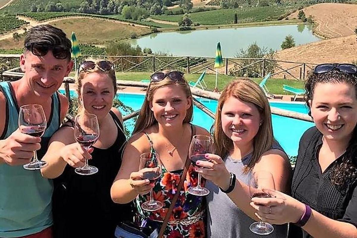un grup de persones amb copes de vi prop d'una piscina