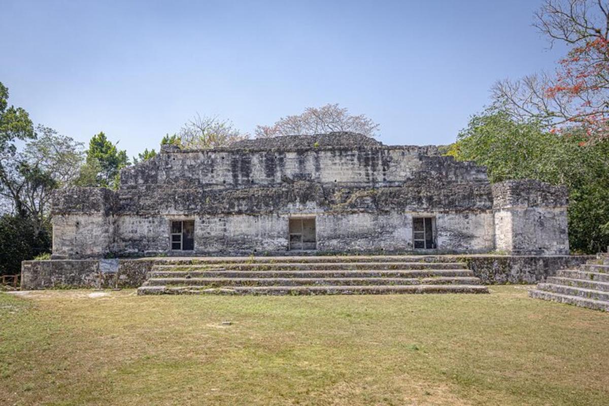 an old stone building with stairs in a field