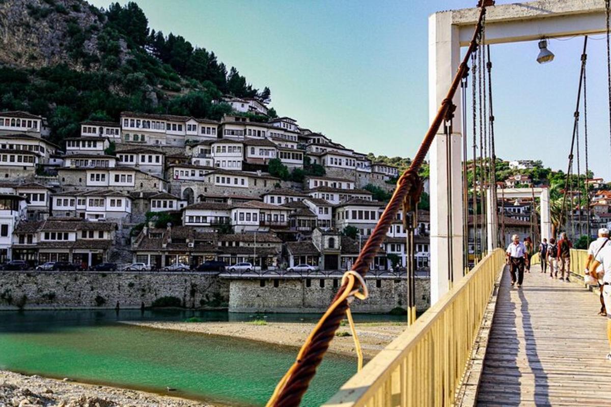 uma ponte sobre um rio com casas em uma colina