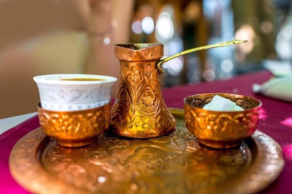 một cái đĩa có một cái bình và hai cái cốc trên bàn