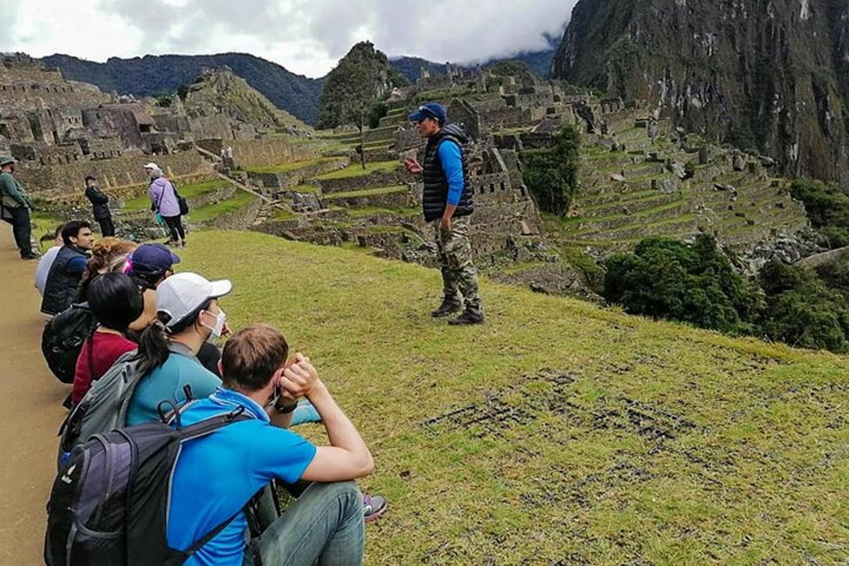 un gruppo di persone che guarda un uomo in piedi su una montagna