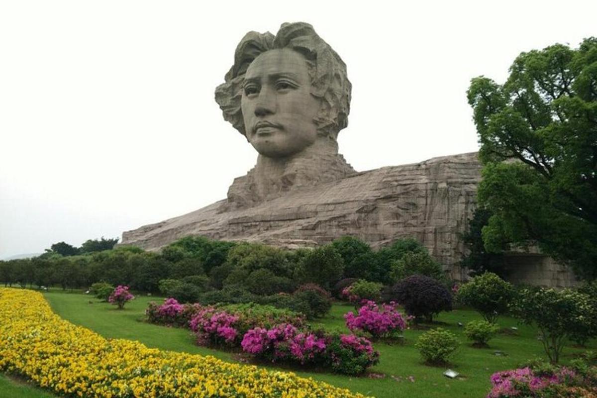 a statue of a woman in a field of flowers