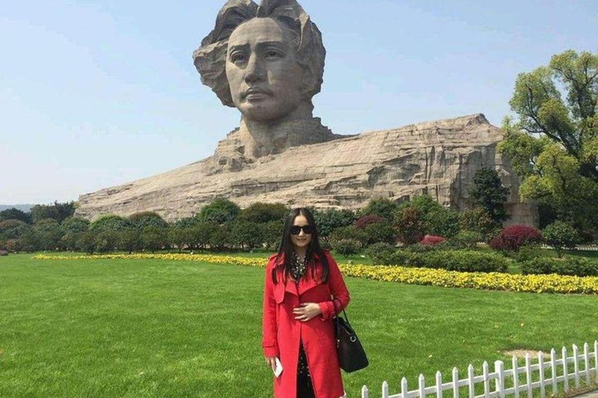 a woman standing in front of a statue