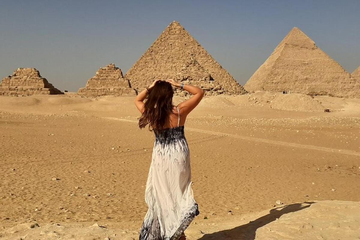 a woman standing in front of the pyramids