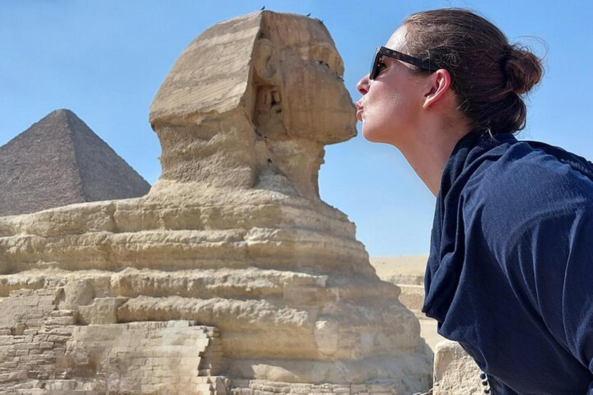 nainen seisoo pyramidien edessä