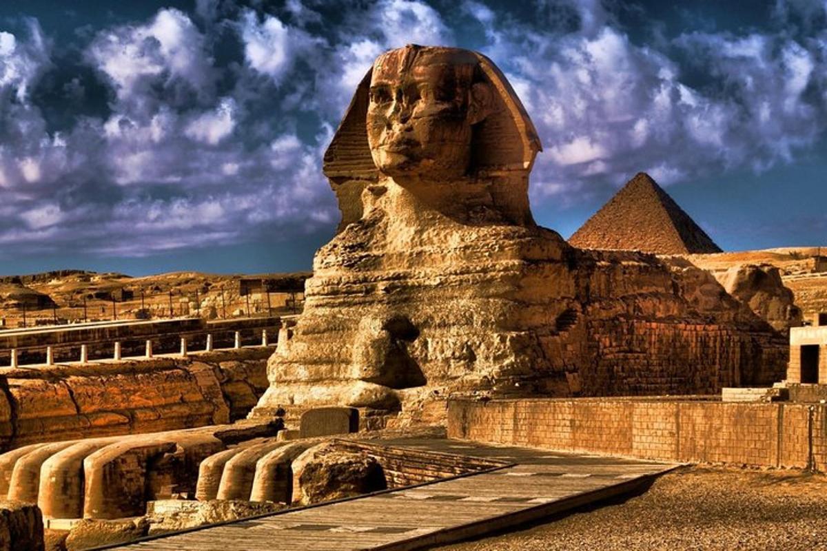 en statue av et hode foran pyramidene