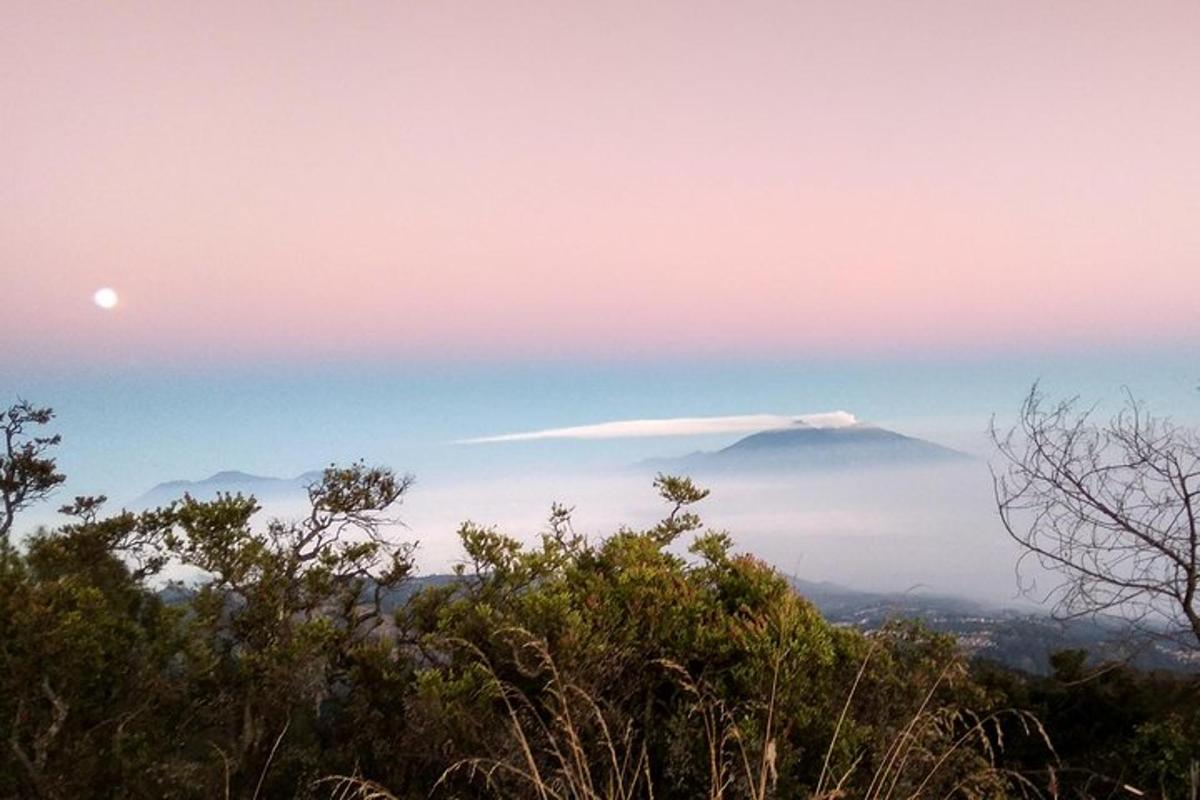 a mountain in the distance with a cloud in the sky