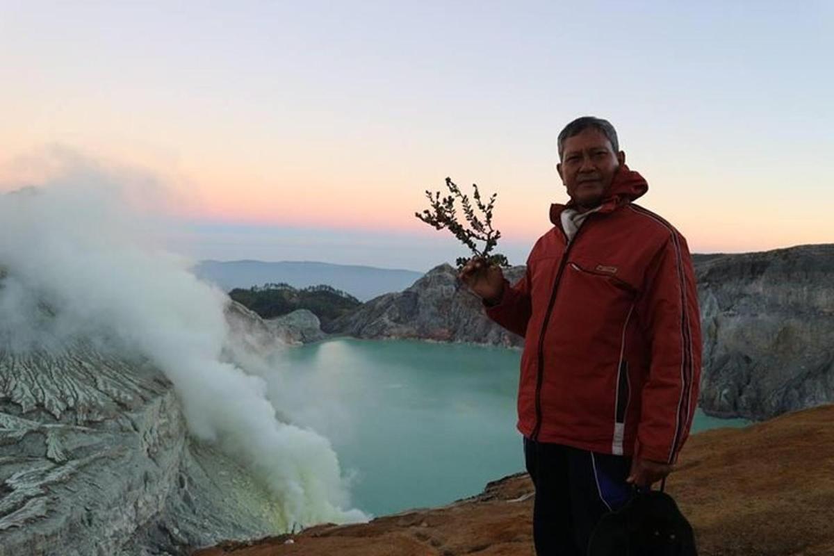a man standing on top of a mountain with a eruption