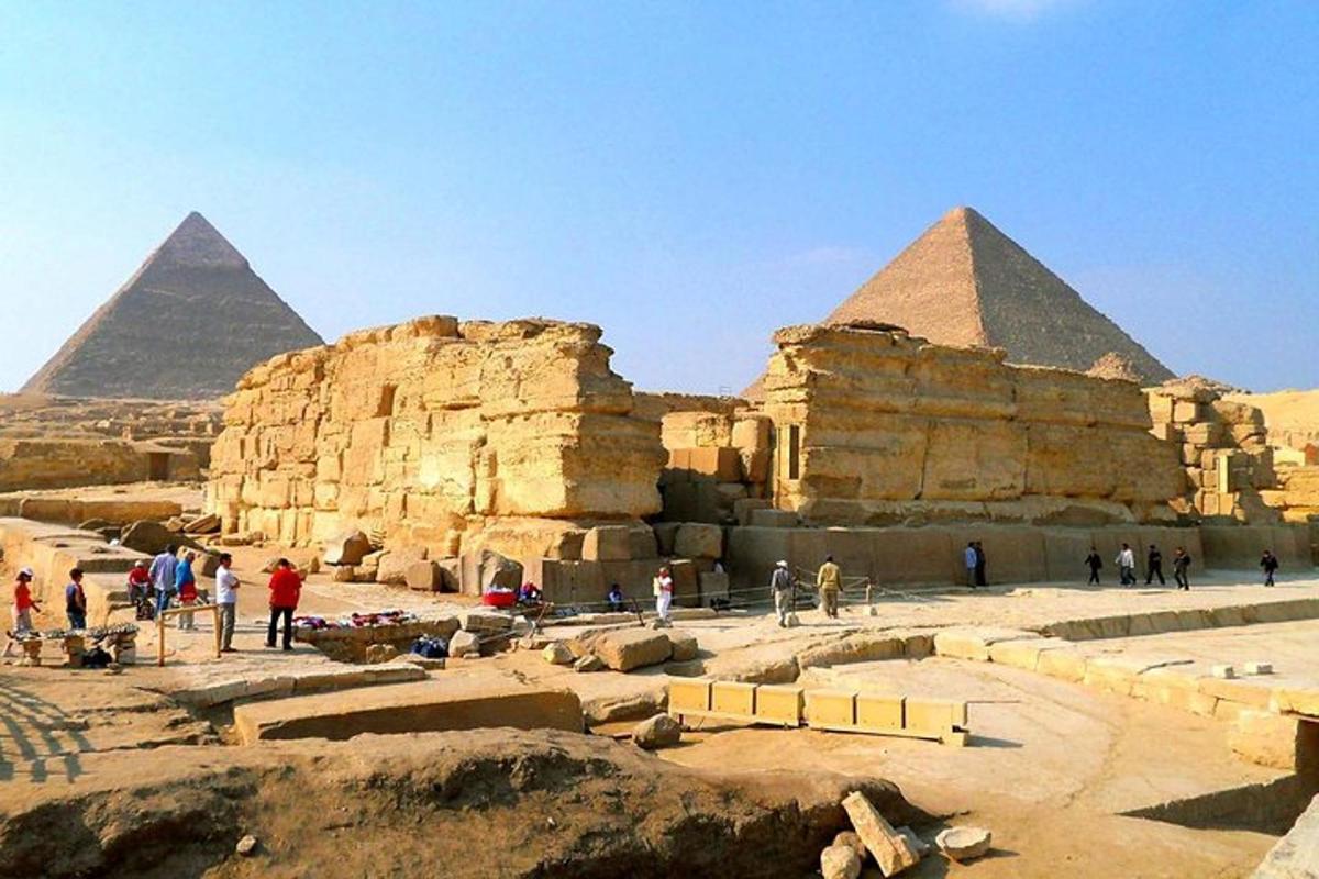 un groupe de personnes debout devant les pyramides