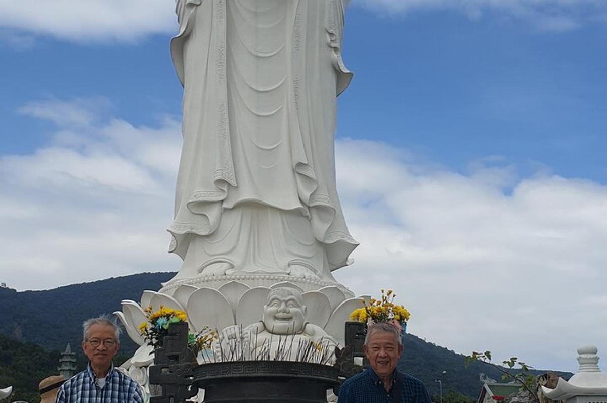two men standing in front of a large statue