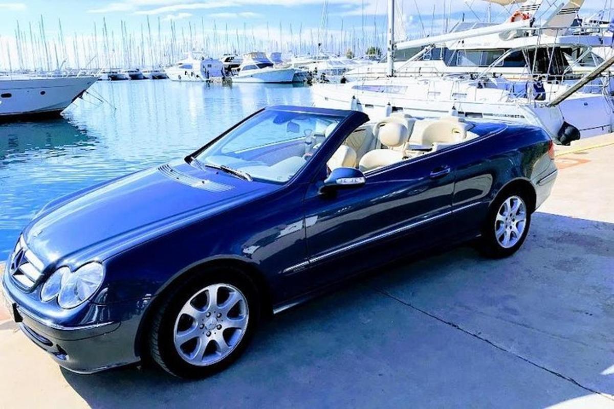 sebuah kereta biru diletakkan di marina dengan bot