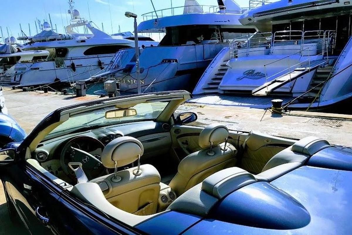 sebuah kereta diletakkan di marina di sebelah bot