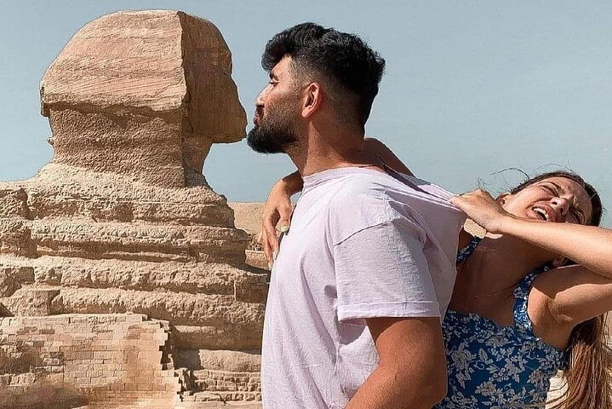 un uomo e una donna in piedi davanti a una piramide