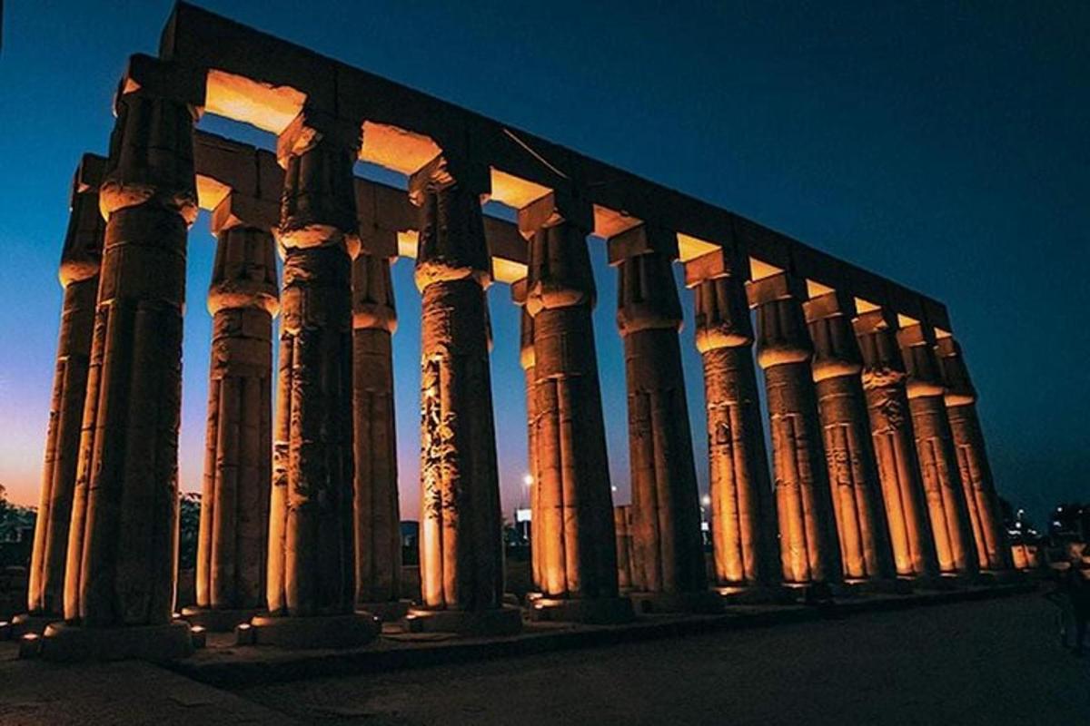 Un edificio iluminado con columnas por la noche.