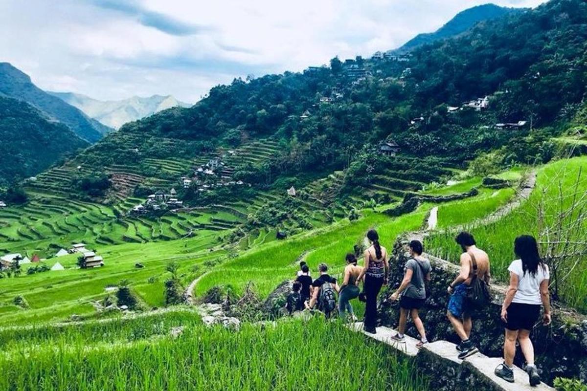a group of people standing on a ledge overlooking a valley