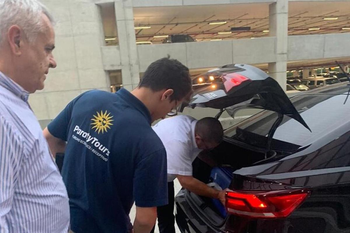skupina moških, ki delajo na pokrovu motorja avtomobila