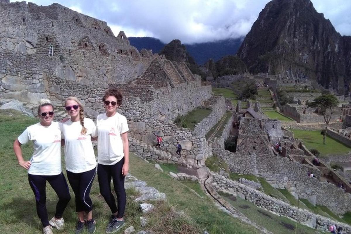 three women standing in front of a ruins