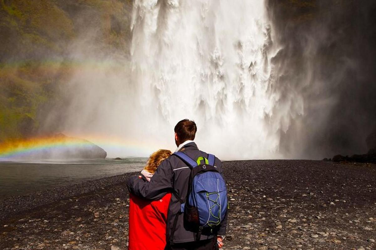 Maður og kona standa fyrir framan foss