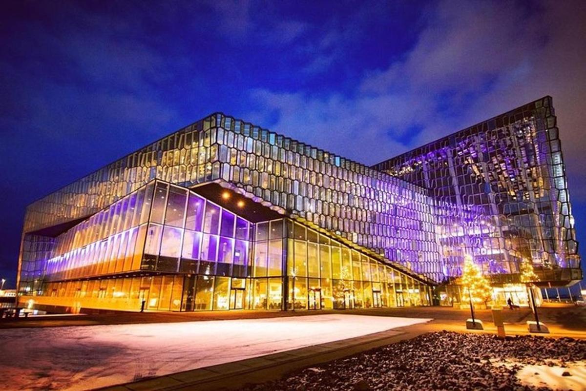 a large glass building with purple lights on it