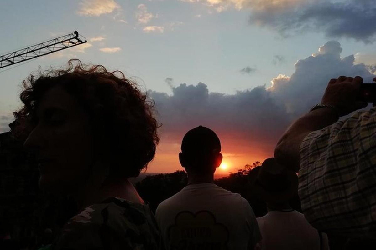 a group of people taking pictures of the sunset
