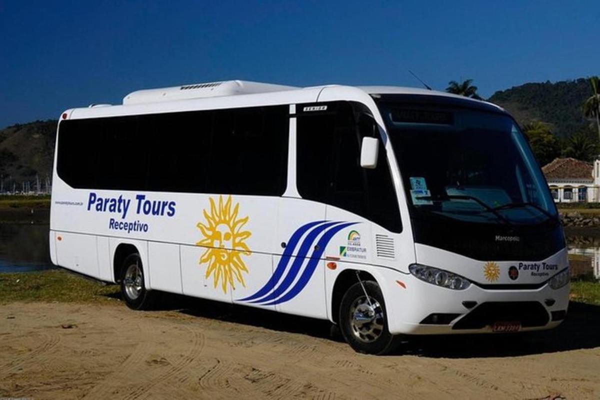 un autobús blanco estacionado en un camino de tierra