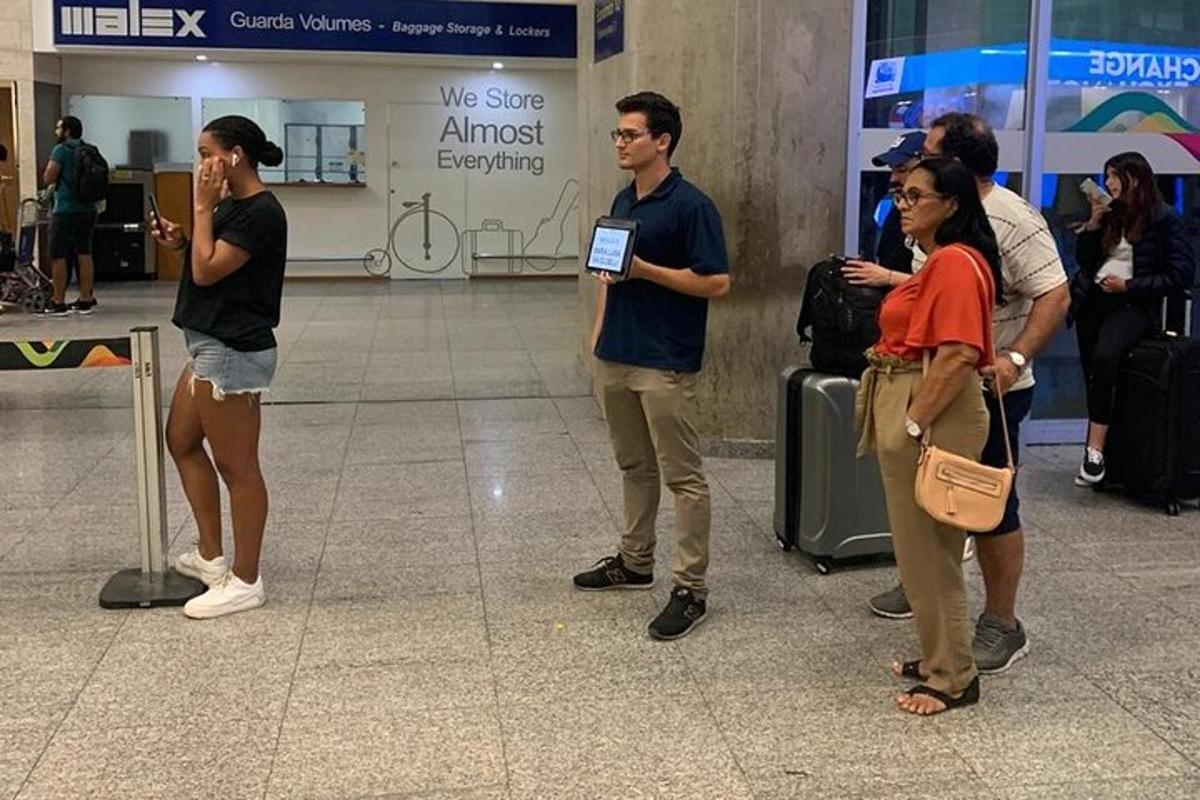 skupina lidí čekajících na svá zavazadla na letišti