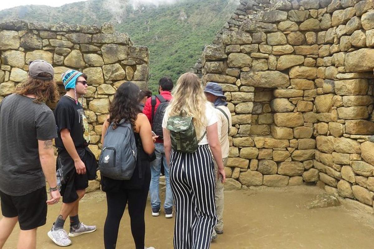 un gruppo di persone in piedi attorno a un muro di pietra