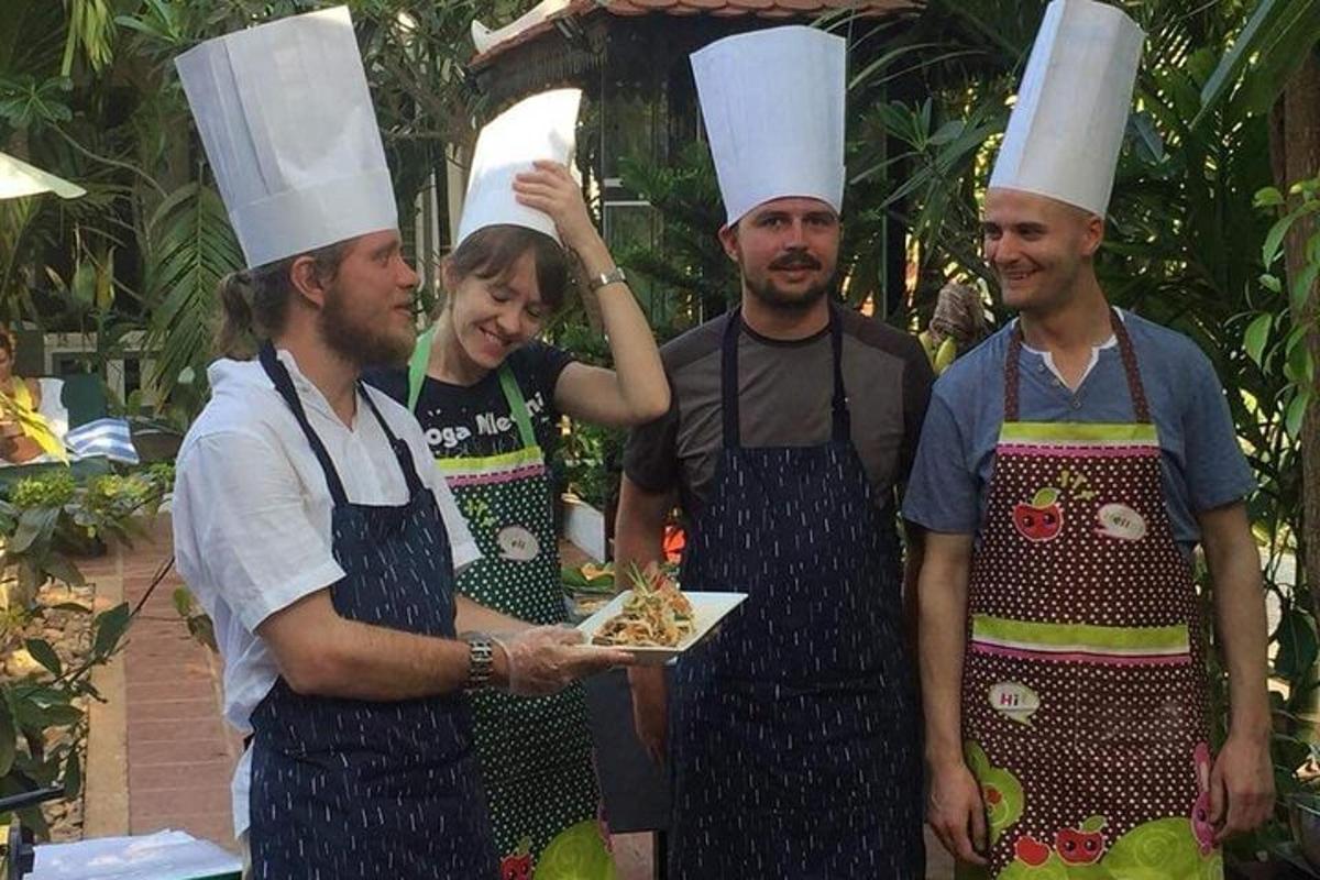 un grup de persones amb barrets de xef sostenint un plat de menjar