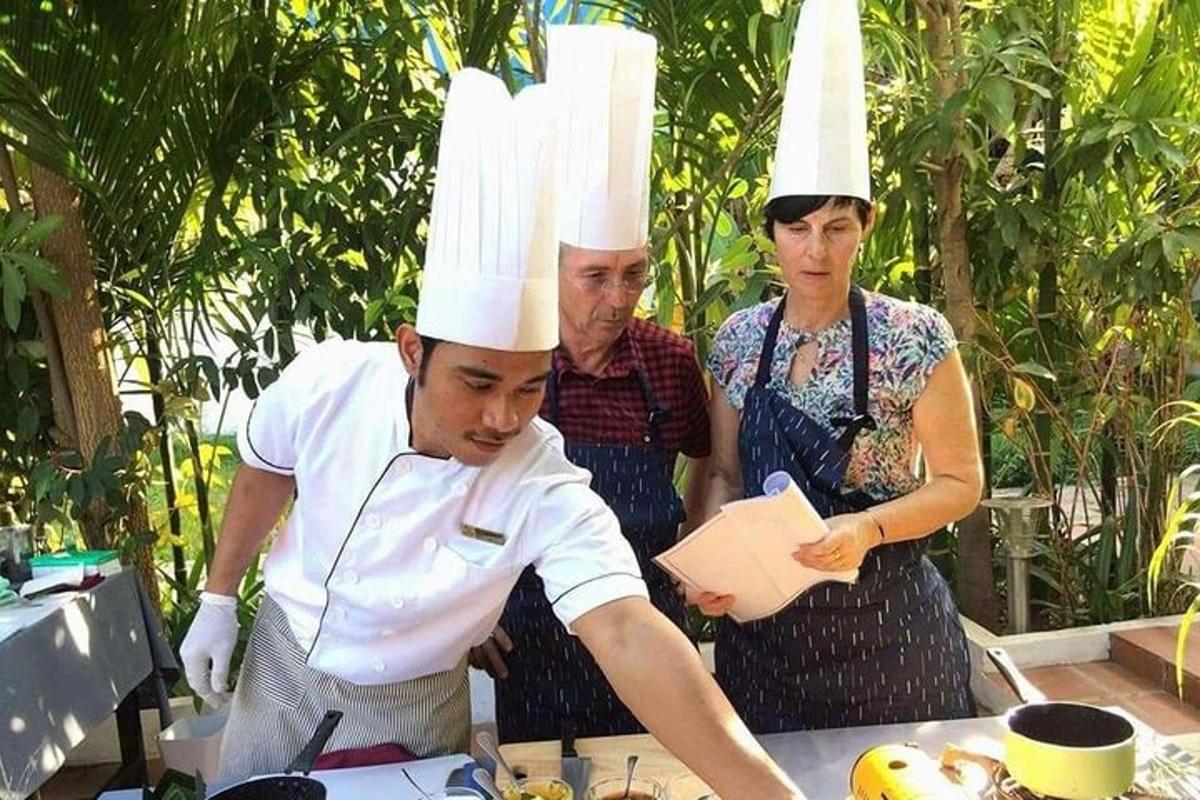 un home amb barrets de xef dret a una taula