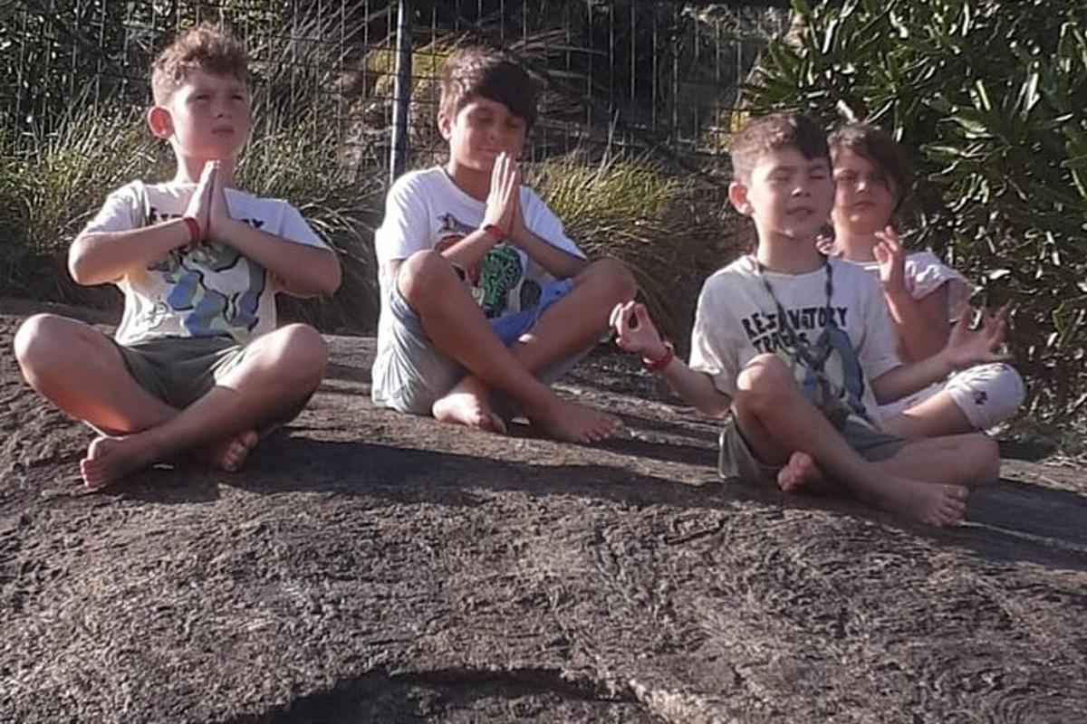 quattro ragazzi seduti a terra con le dita in bocca