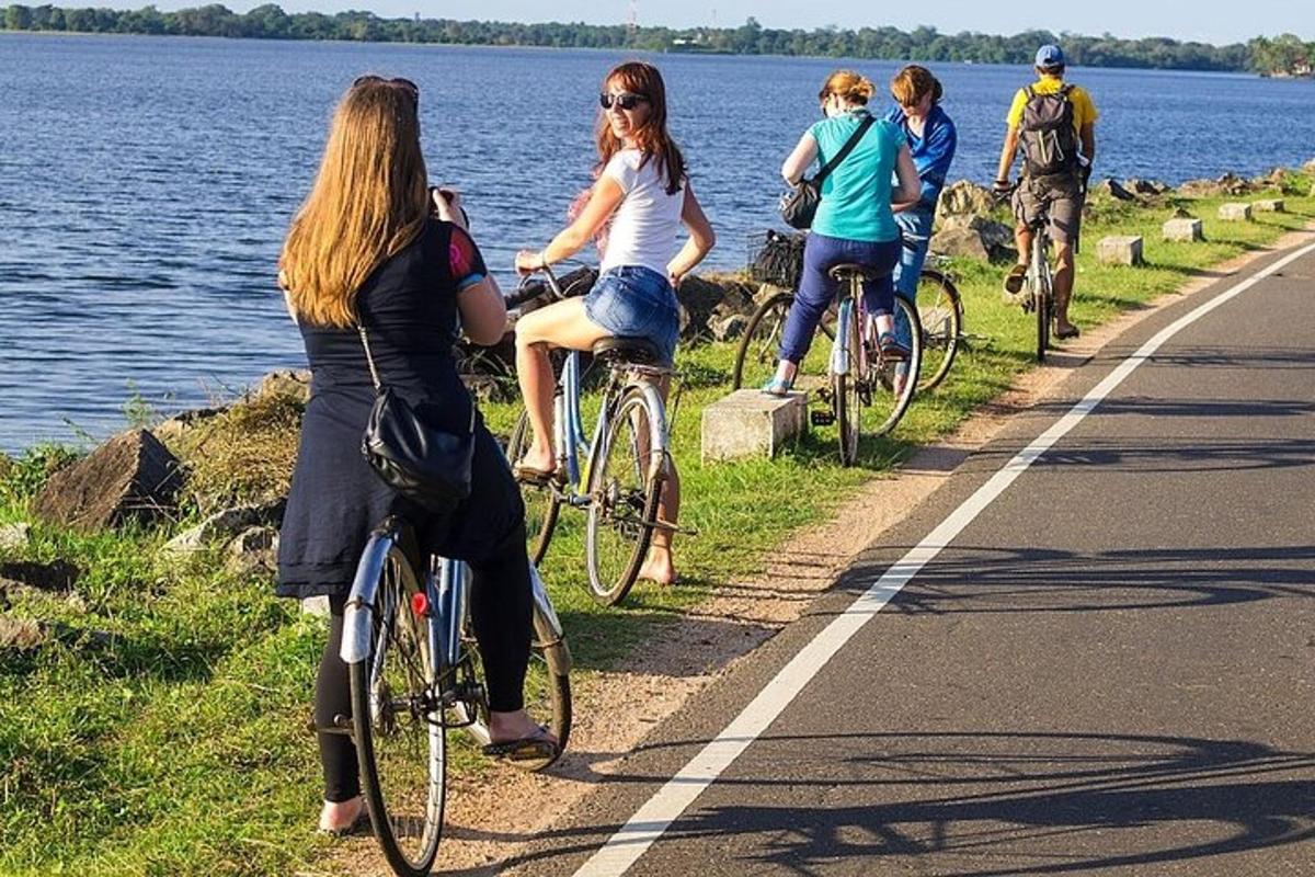 hópur fólks á hjólum eftir vegi við vatnið