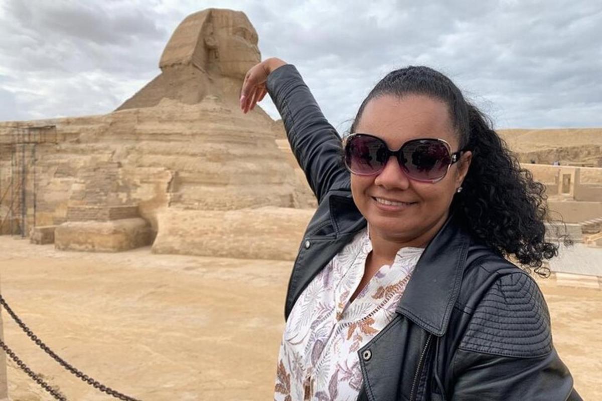 a woman wearing sunglasses standing in front of the pyramid