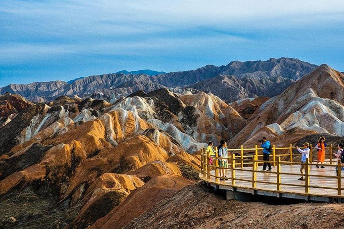 a group of people standing on a viewing platform on a mountain