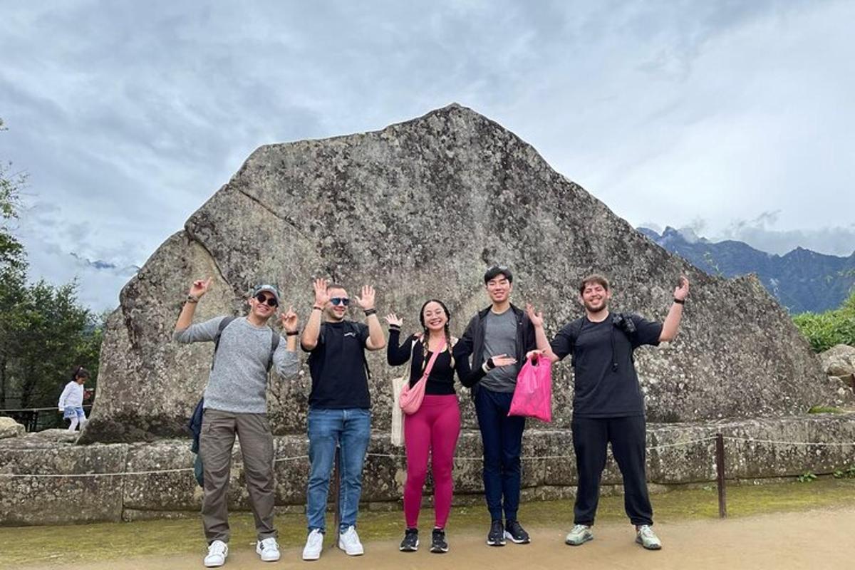 un gruppo di persone in piedi davanti a una roccia