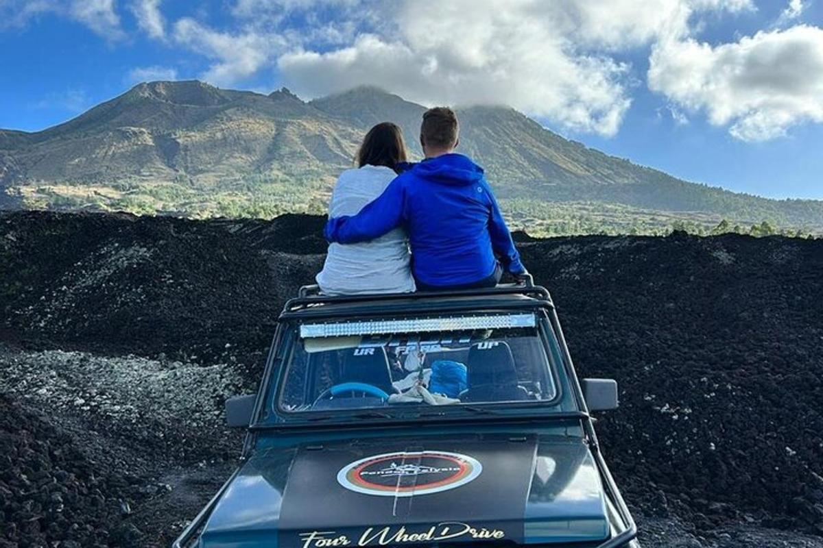 Maður og kona sitjandi á þaki jeppa