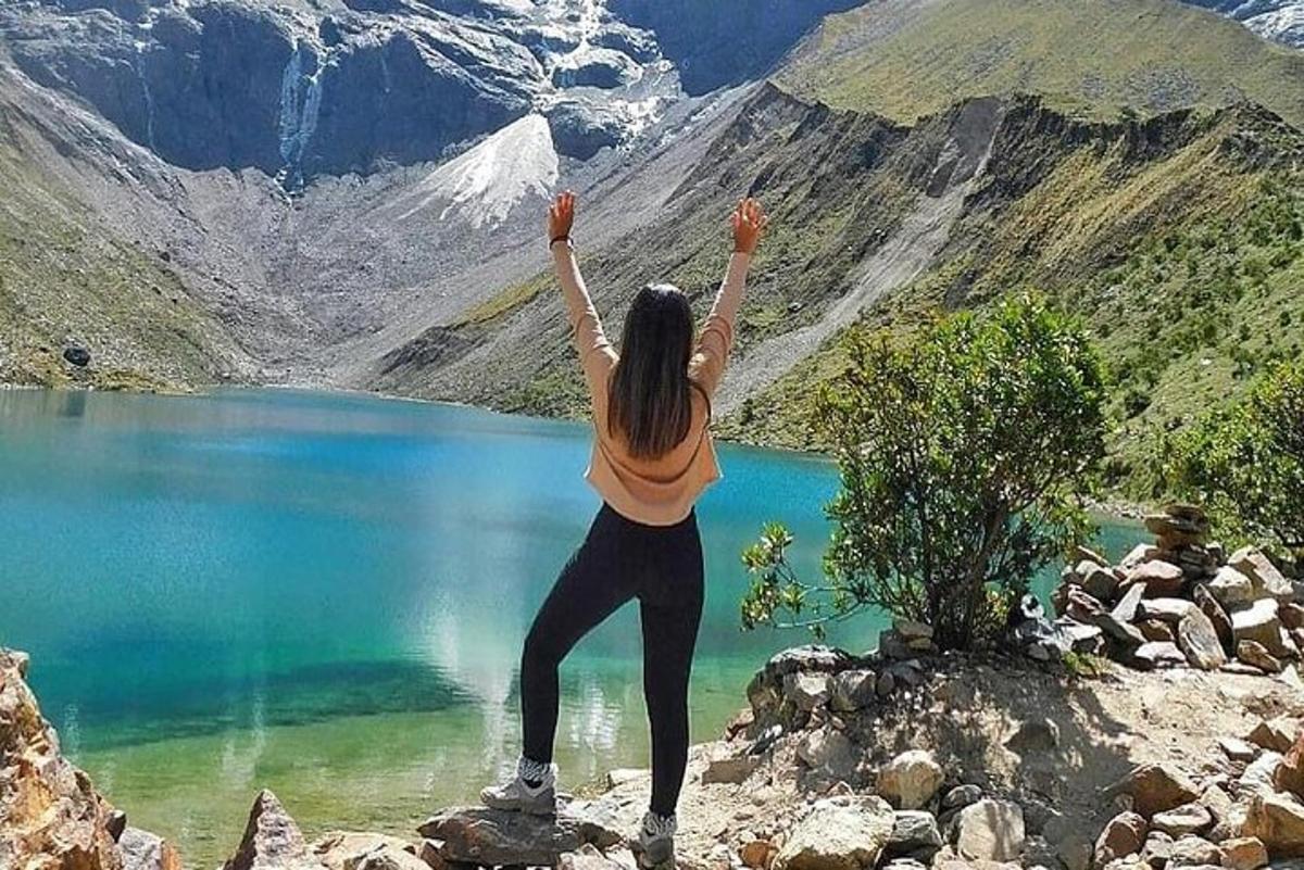 Una mujer haciendo una pose de yoga frente a un lago.