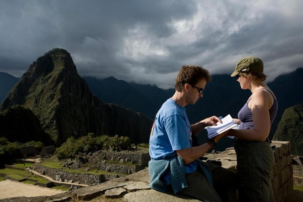 Ein Mann und eine Frau sitzen auf einem Felsen und schauen sich ein Buch an