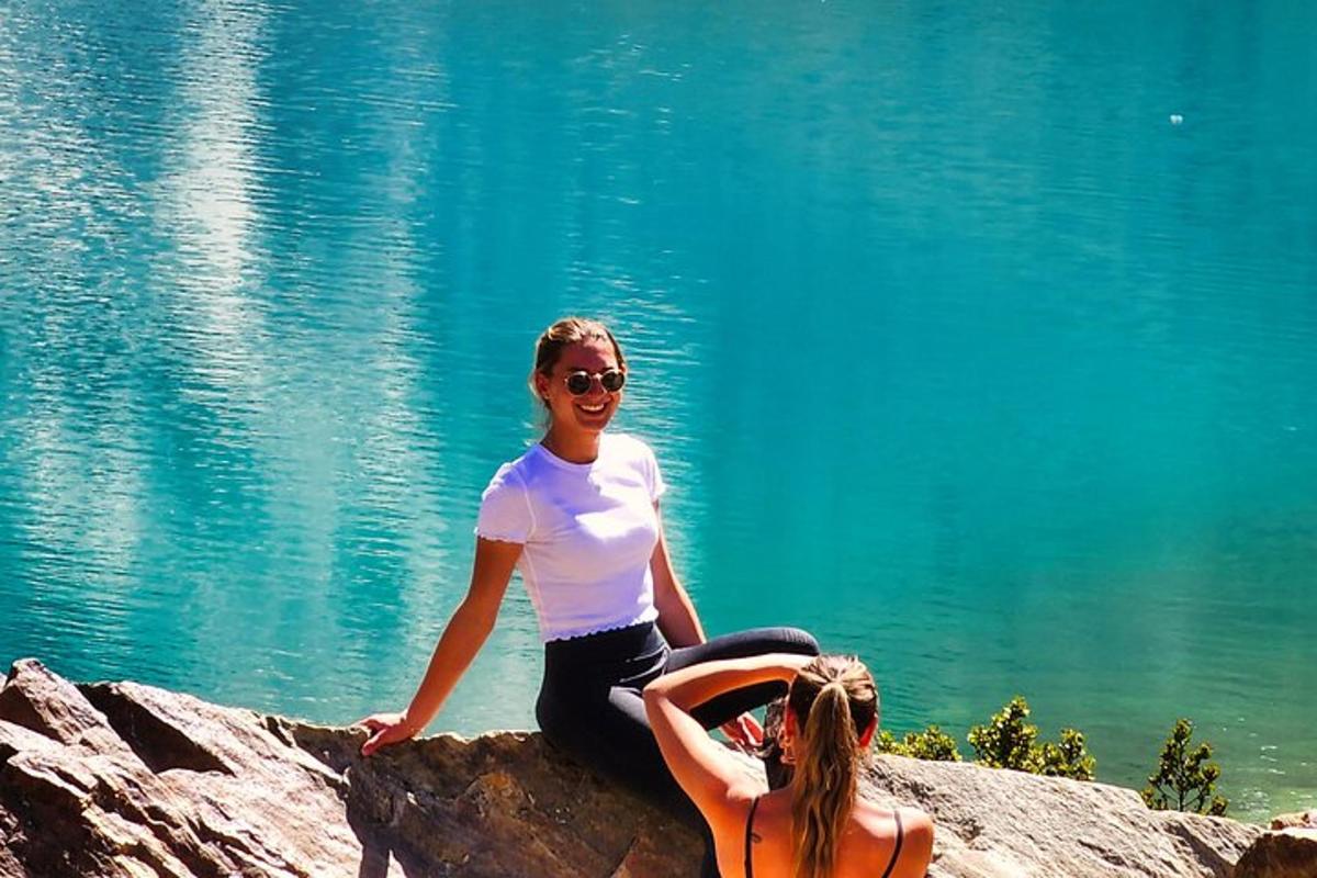 due ragazze sedute su una roccia vicino all'acqua