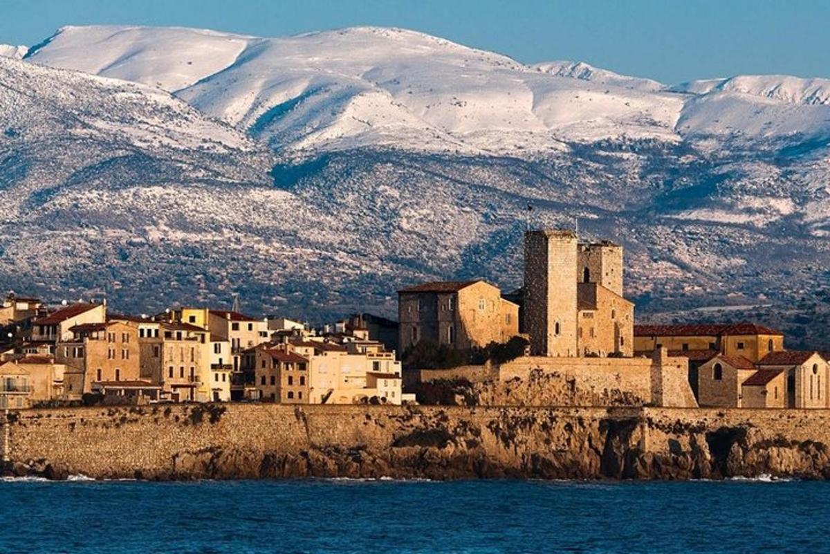 una città su una collina con montagne coperte di neve